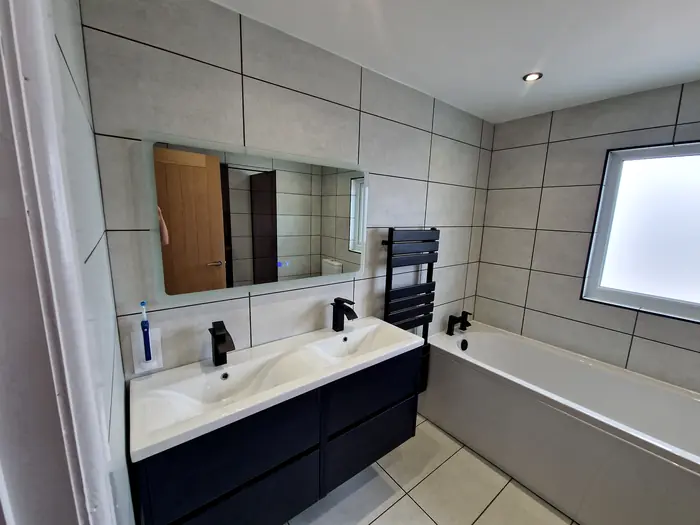 Bathroom with two basins on a dark vanity unit