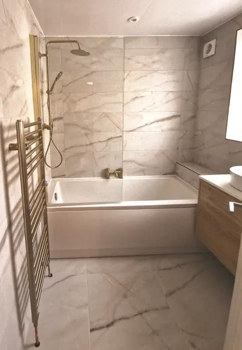 Marble-effect bathroom with a bath and brushed gold towel rail