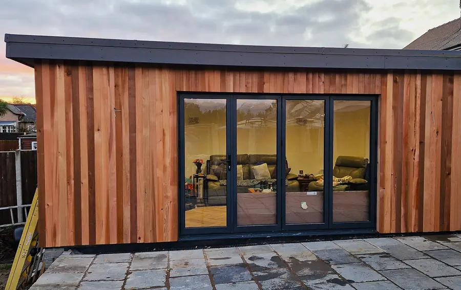 Single-storey extension clad in cedar with black bifold doors