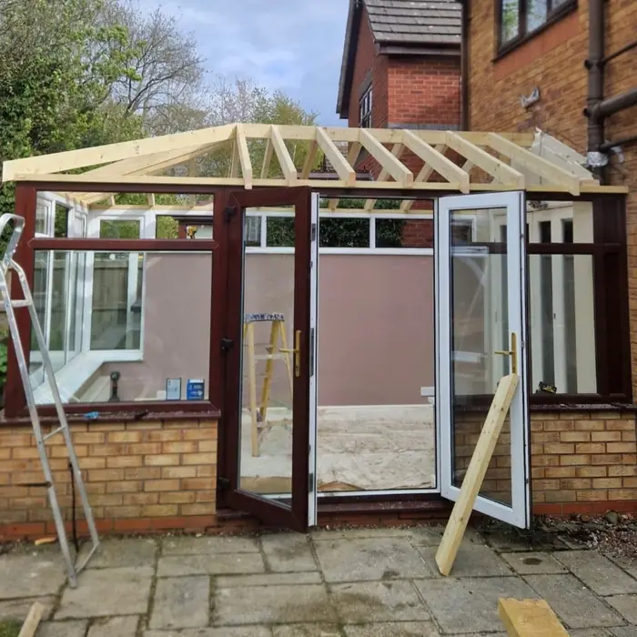 New timber roof frame being built over the conservatory