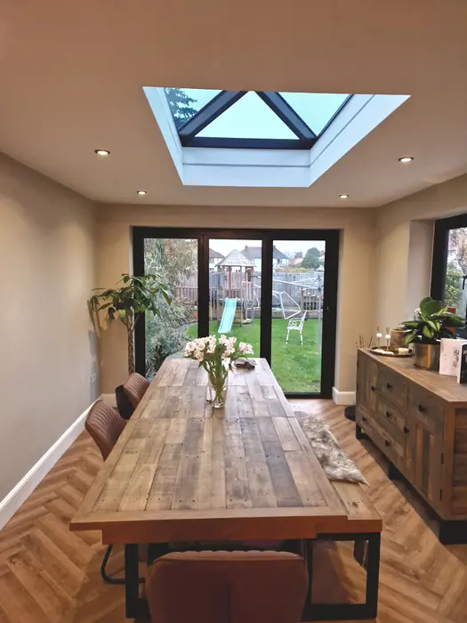 Dining area under a roof lantern with doors onto the garden