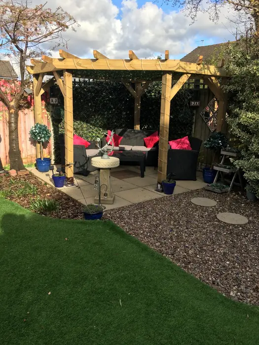 Timber pergola over a patio seating area in a back garden