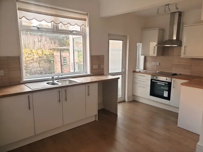 White kitchen with wood-effect flooring in a rental property
