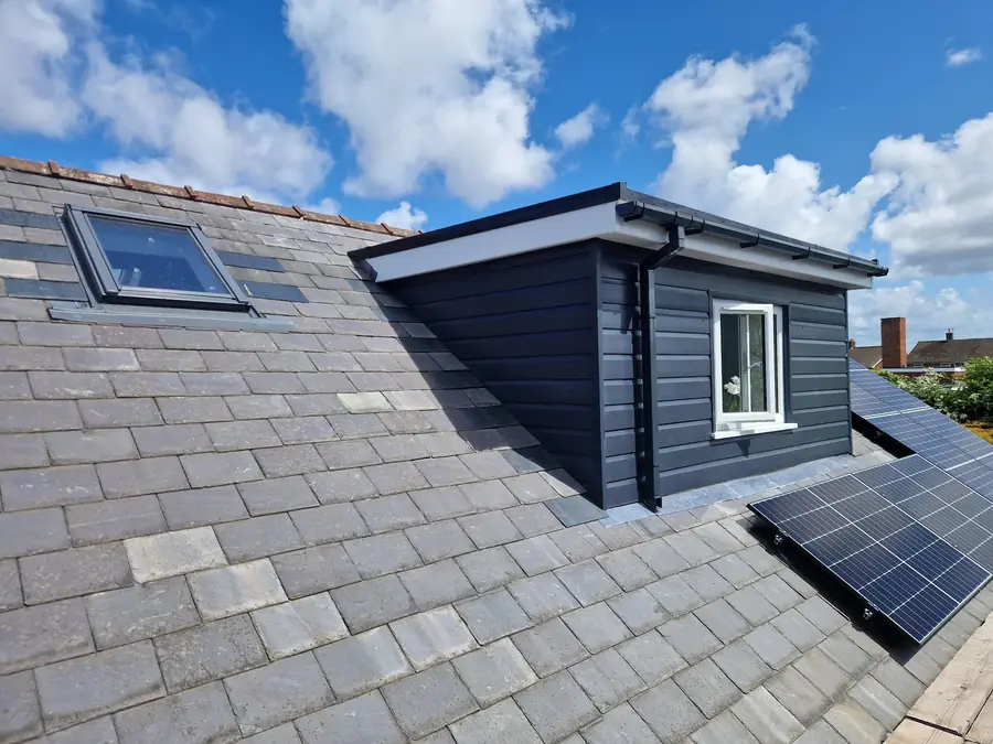 New dormer on a slate roof with a roof window and solar panels